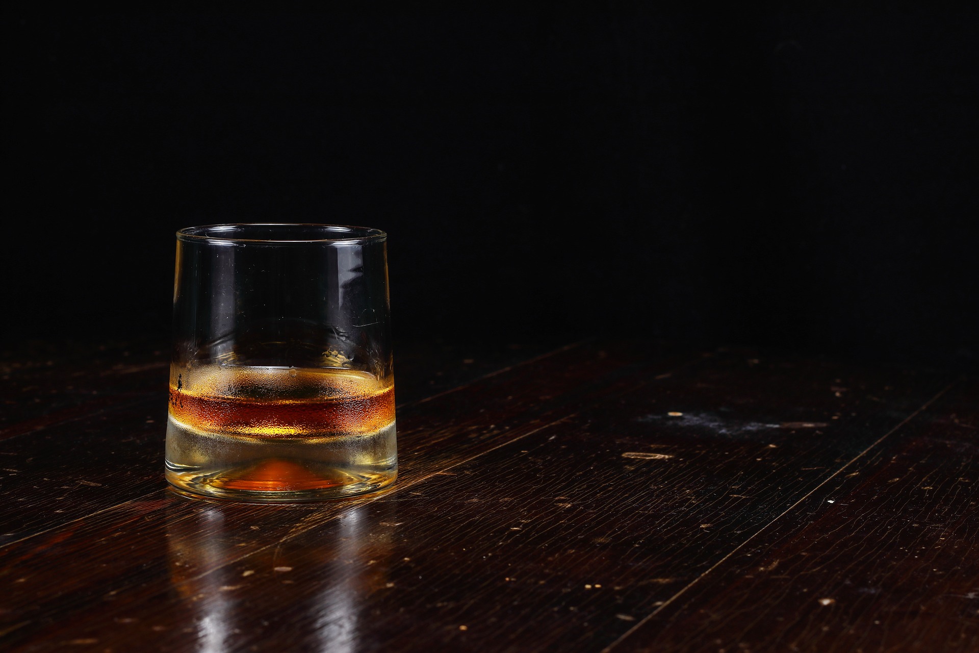 Vaso de whiskey sobre madera envejecida
